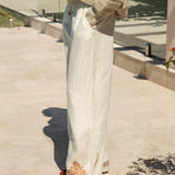 Alba Embroidered Linen Pants showcasing pockets and rust coloured embroidery at hem