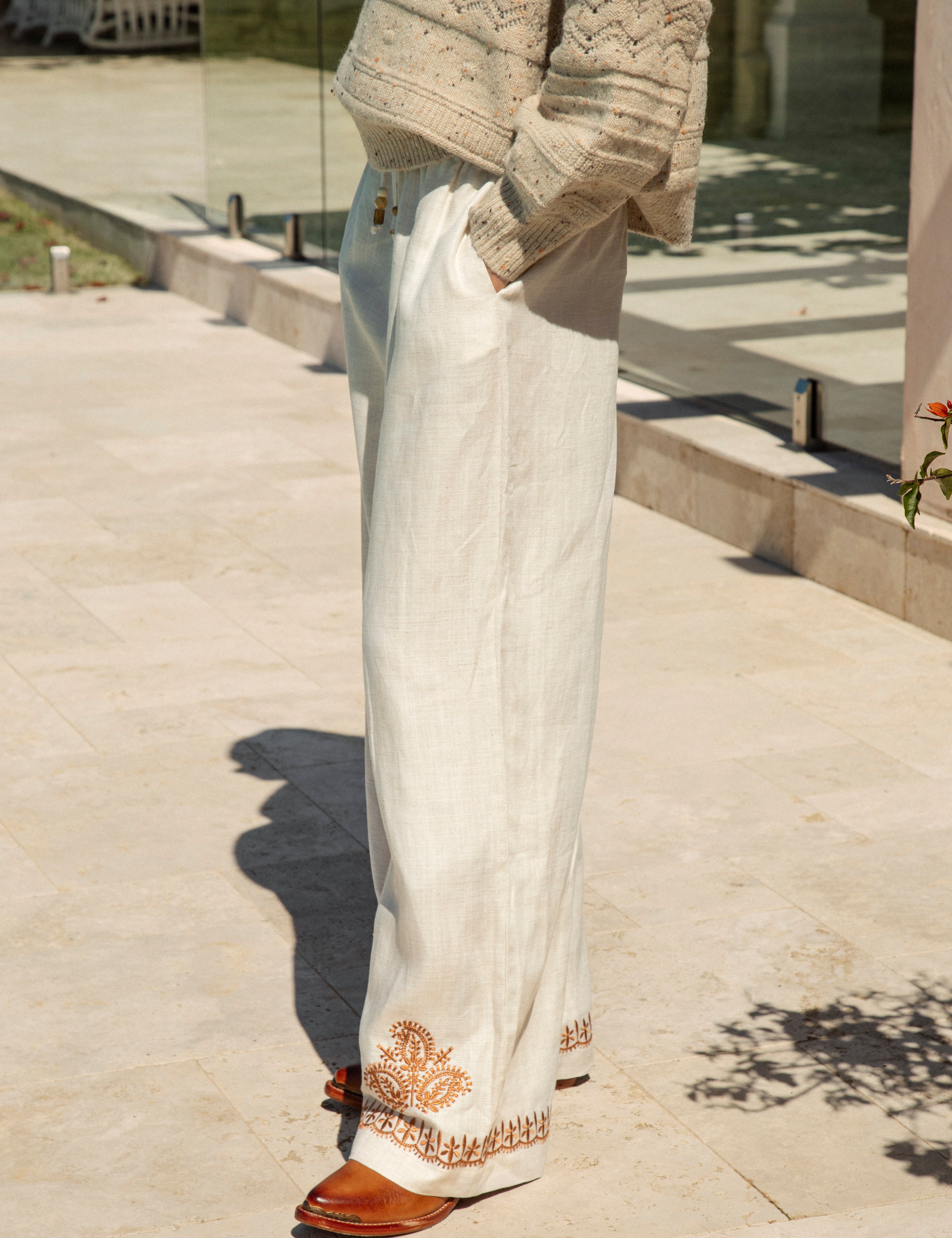 Alba Embroidered Linen Pants showcasing pockets and rust coloured embroidery at hem