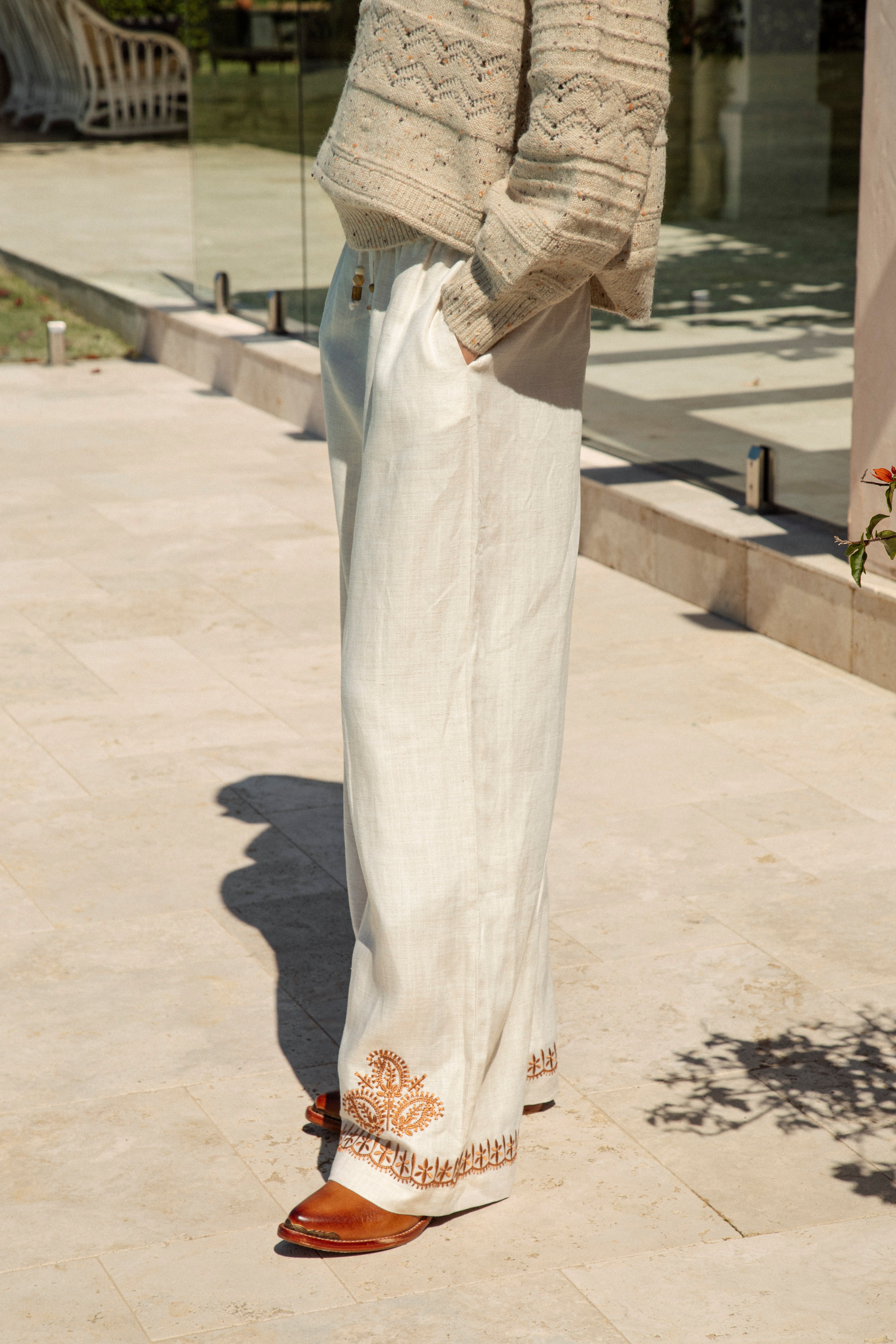 Alba Embroidered Linen Pants showcasing pockets and rust coloured embroidery at hem