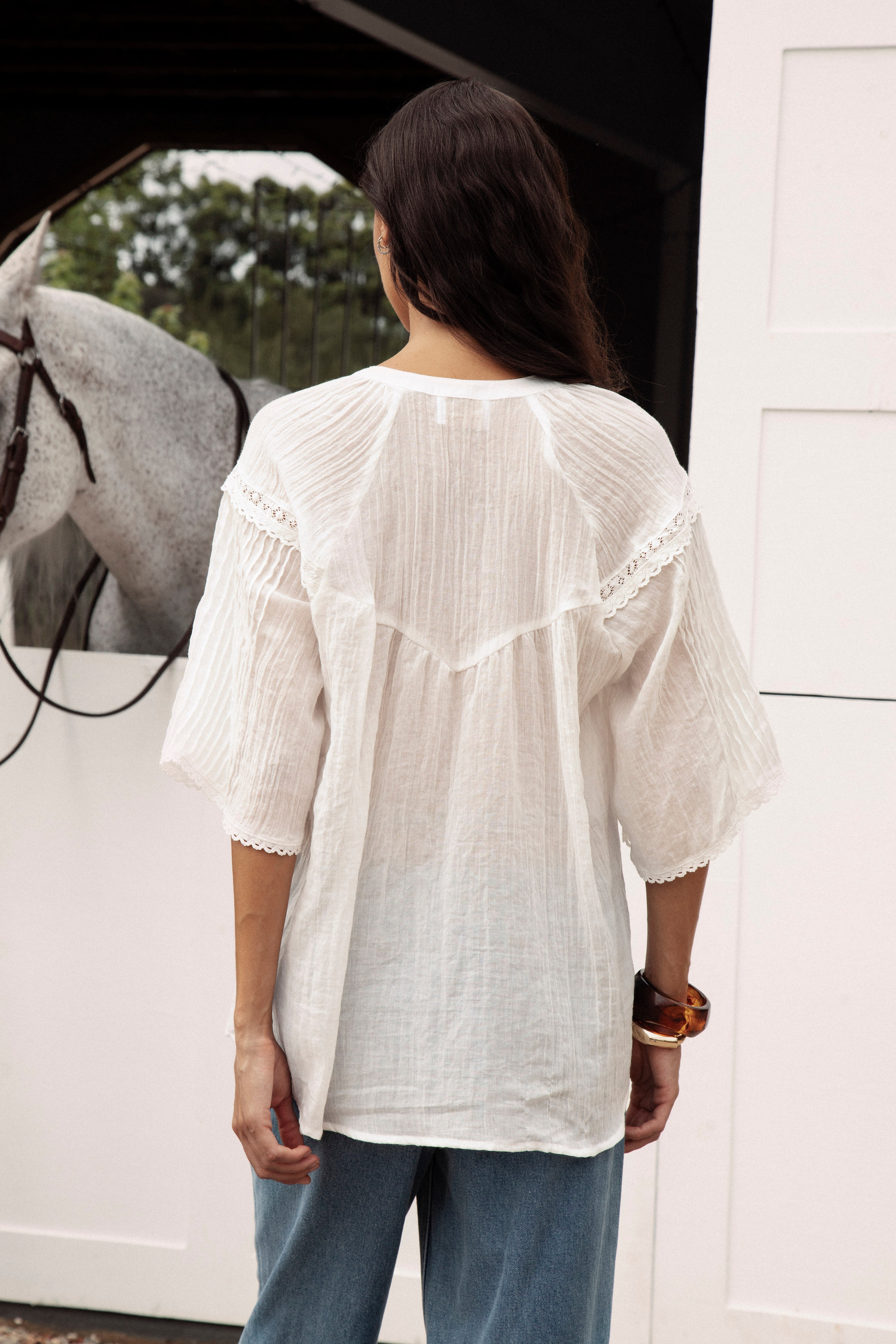 Atti Blouse. Rear View. Delicate white blouse with dropped yoke at rear and lace details.