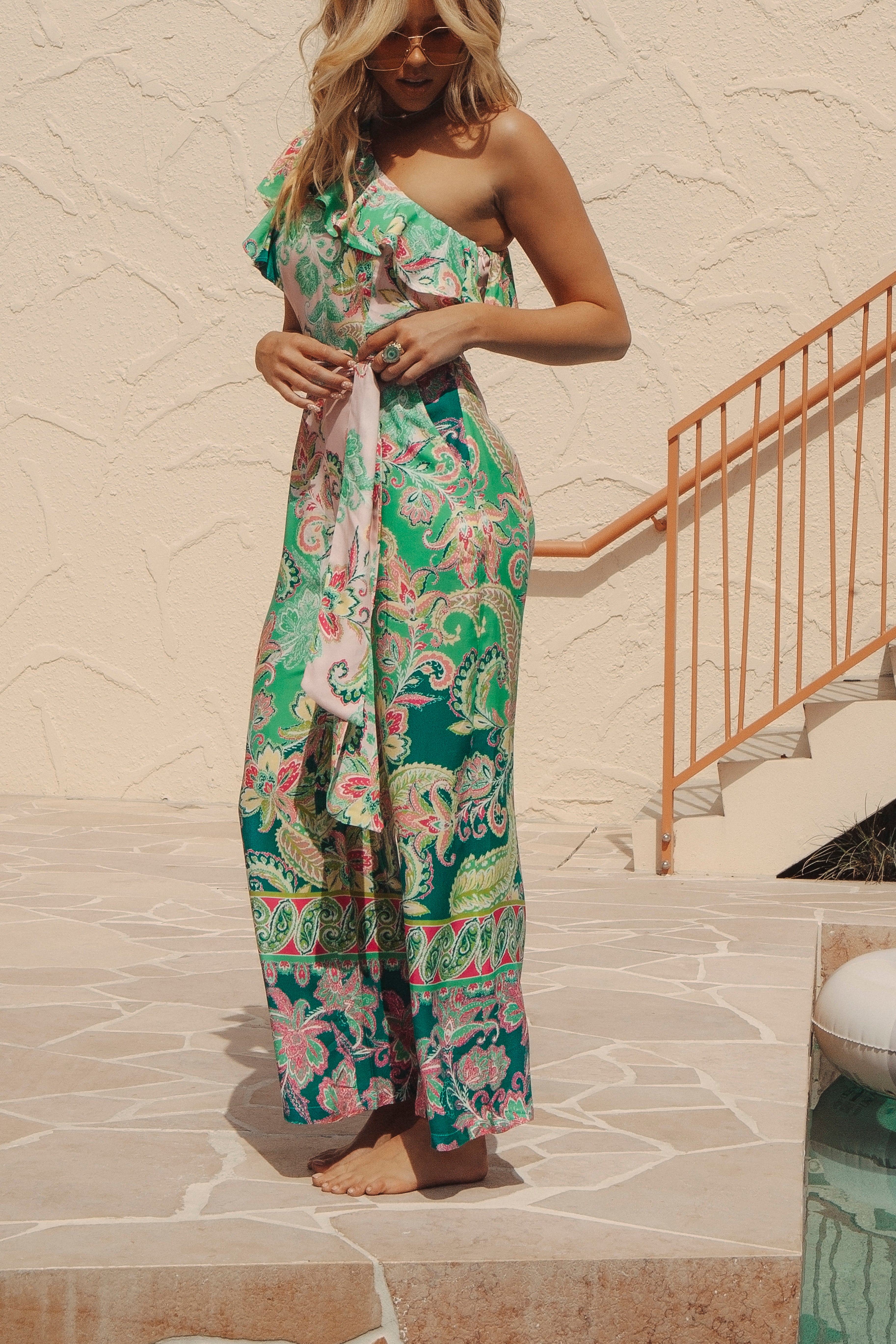 Cantina Jumpsuit Paisley Paradise features one shoulder style, ruffled neckline and tie at waist