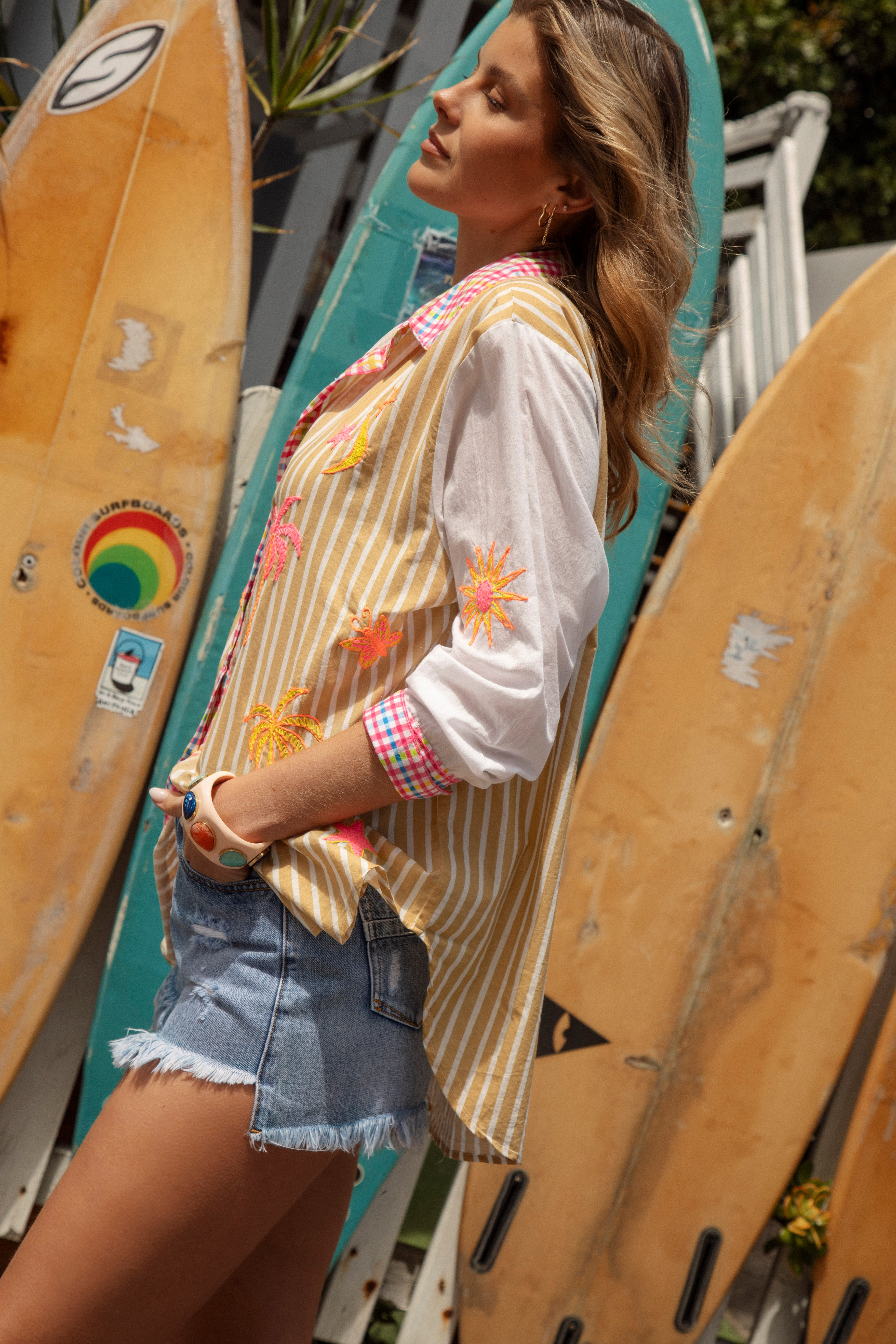 Cosmo Shirt Sandy - side view showcasing contrasting white sleeves with embroidered motifs in shades of yellow, orange and pink.