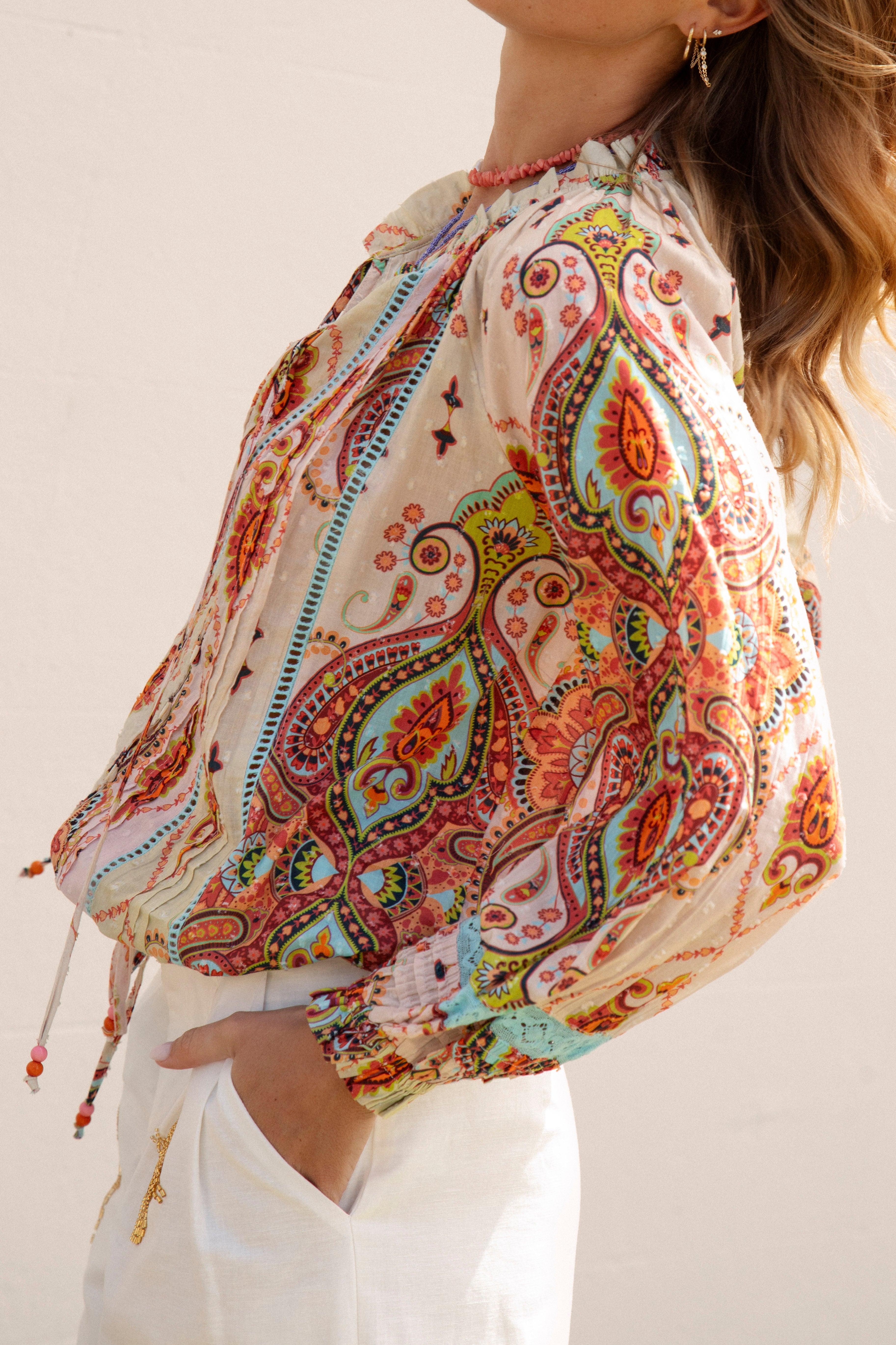 Delfi Blouse Rio - side view showcasing vibrant paisley print, billowy sleeves and shirred cuff detail.