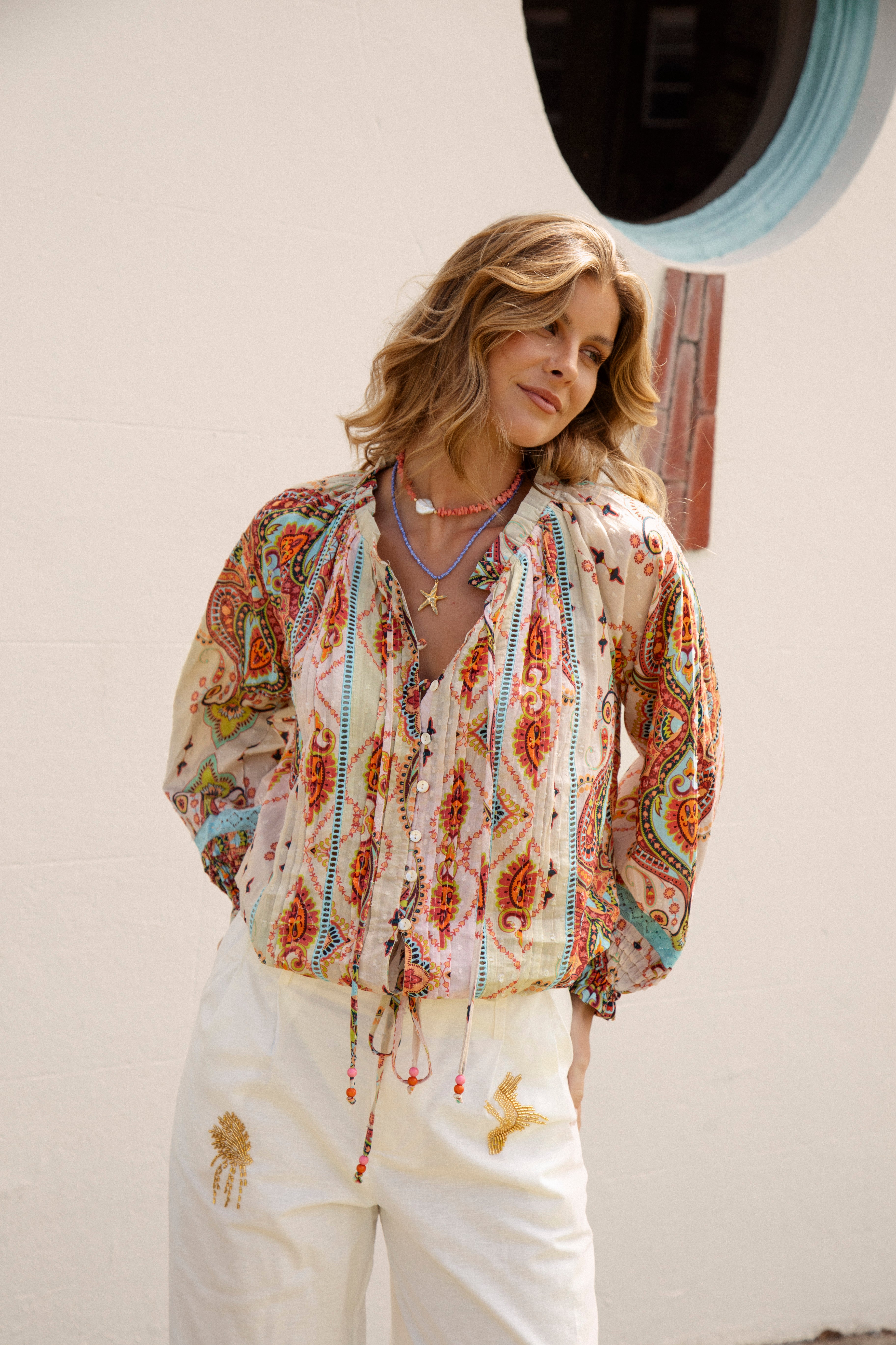 Delfi Blouse Rio features button down style and tie drawstring at waist
