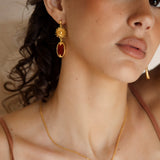 Emberlyn Earrings - gold drop earring with sun motif and ruby red jewel