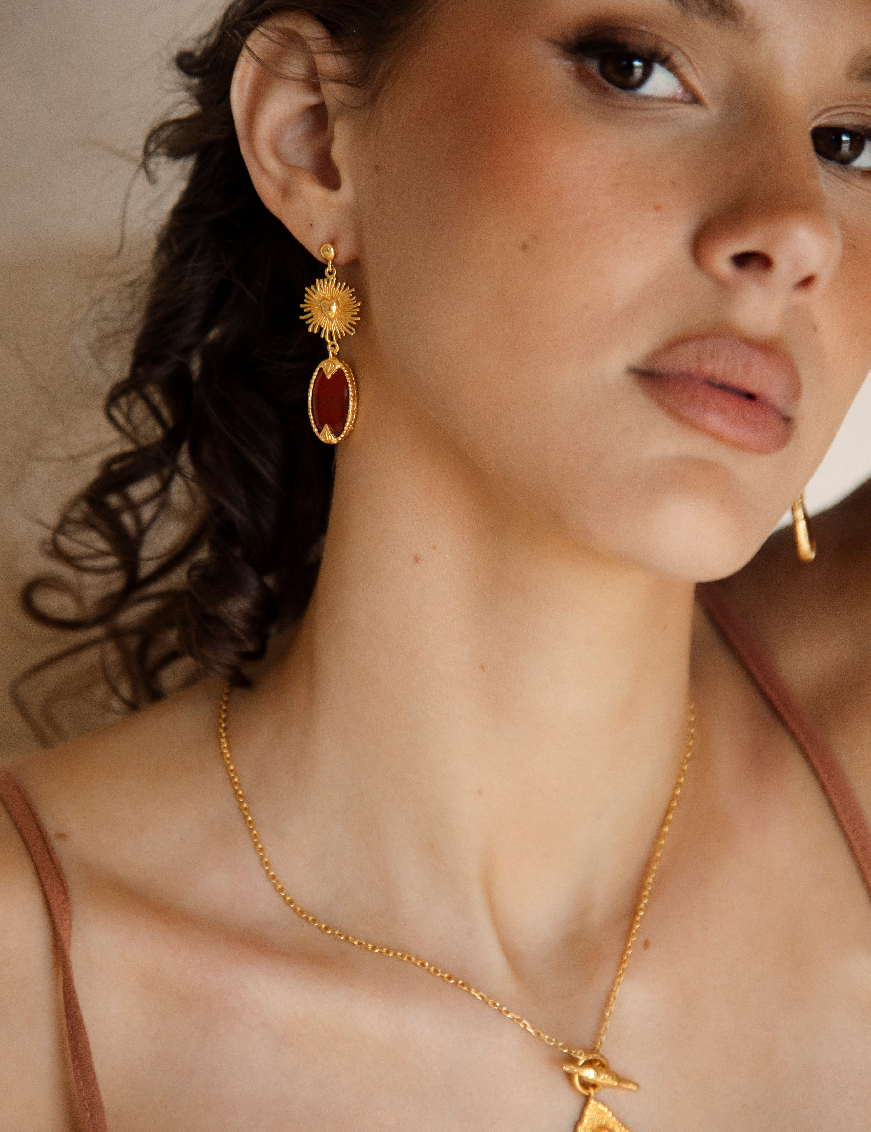 Emberlyn Earrings - gold drop earring with sun motif and ruby red jewel