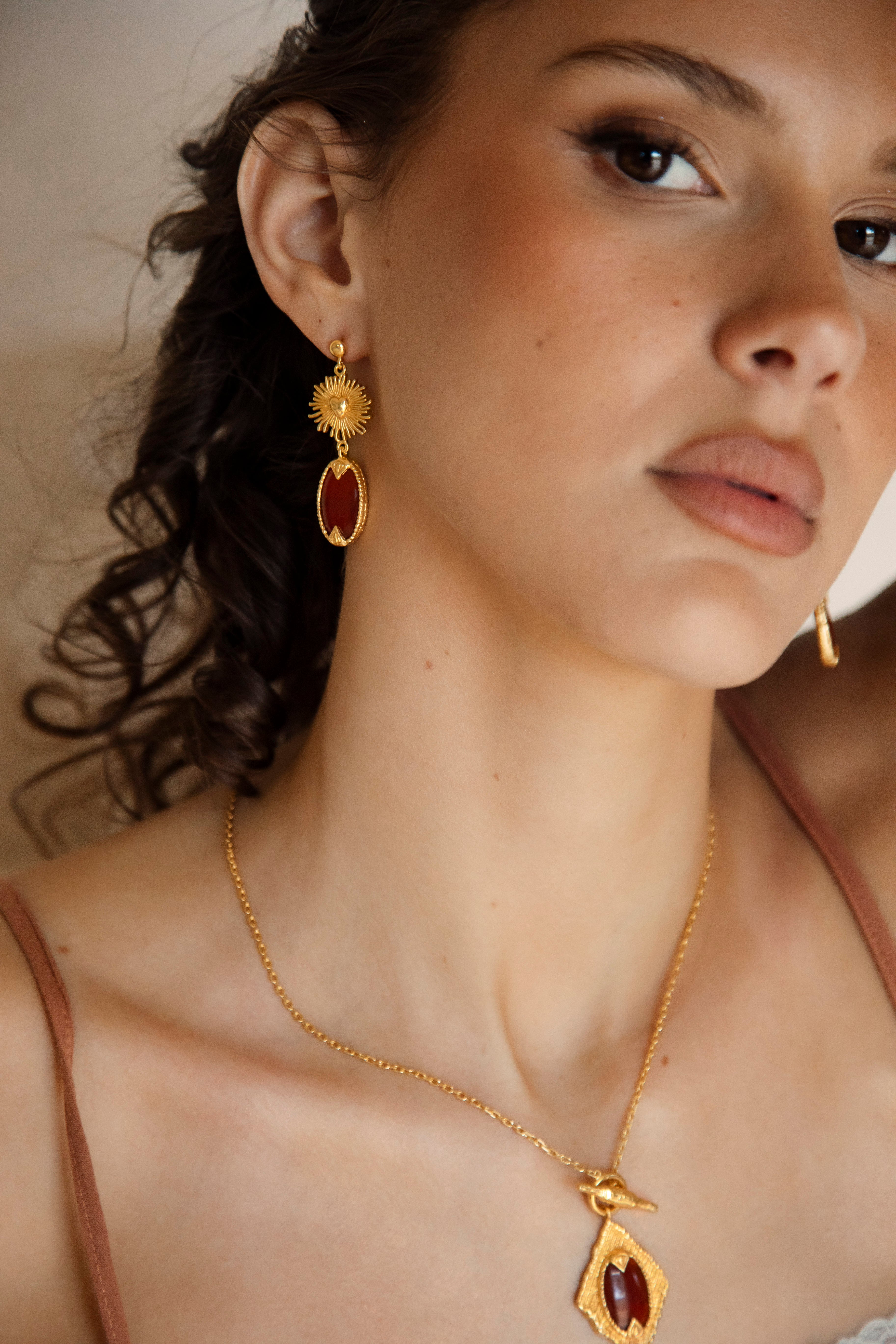 Emberlyn Earrings - gold drop earring with sun motif and ruby red jewel