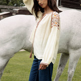 Eve Embroidered Blouse is a cream coloured long sleeve Boho style blouse with delicate embroidery at sleeves in shades of yellow, brown and pink.