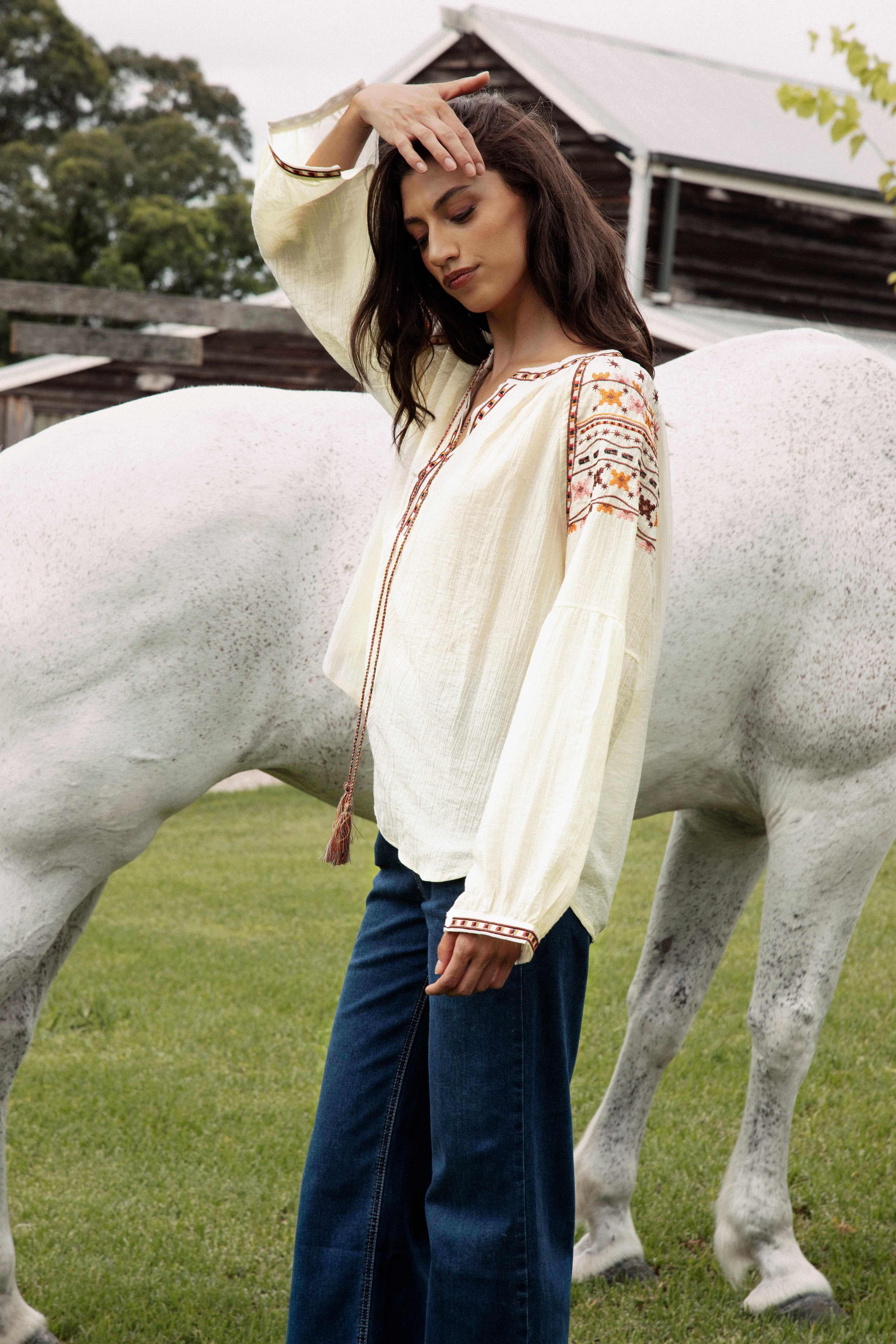 Eve Embroidered Blouse is a cream coloured long sleeve Boho style blouse with delicate embroidery at sleeves in shades of yellow, brown and pink.
