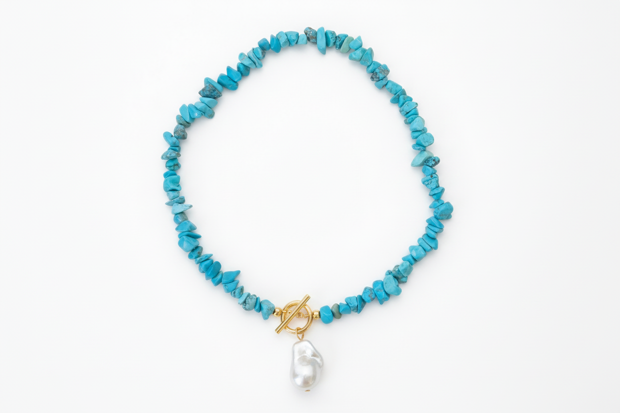 Turquoise beaded necklace with a gold clasp and pearl pendant on a white background