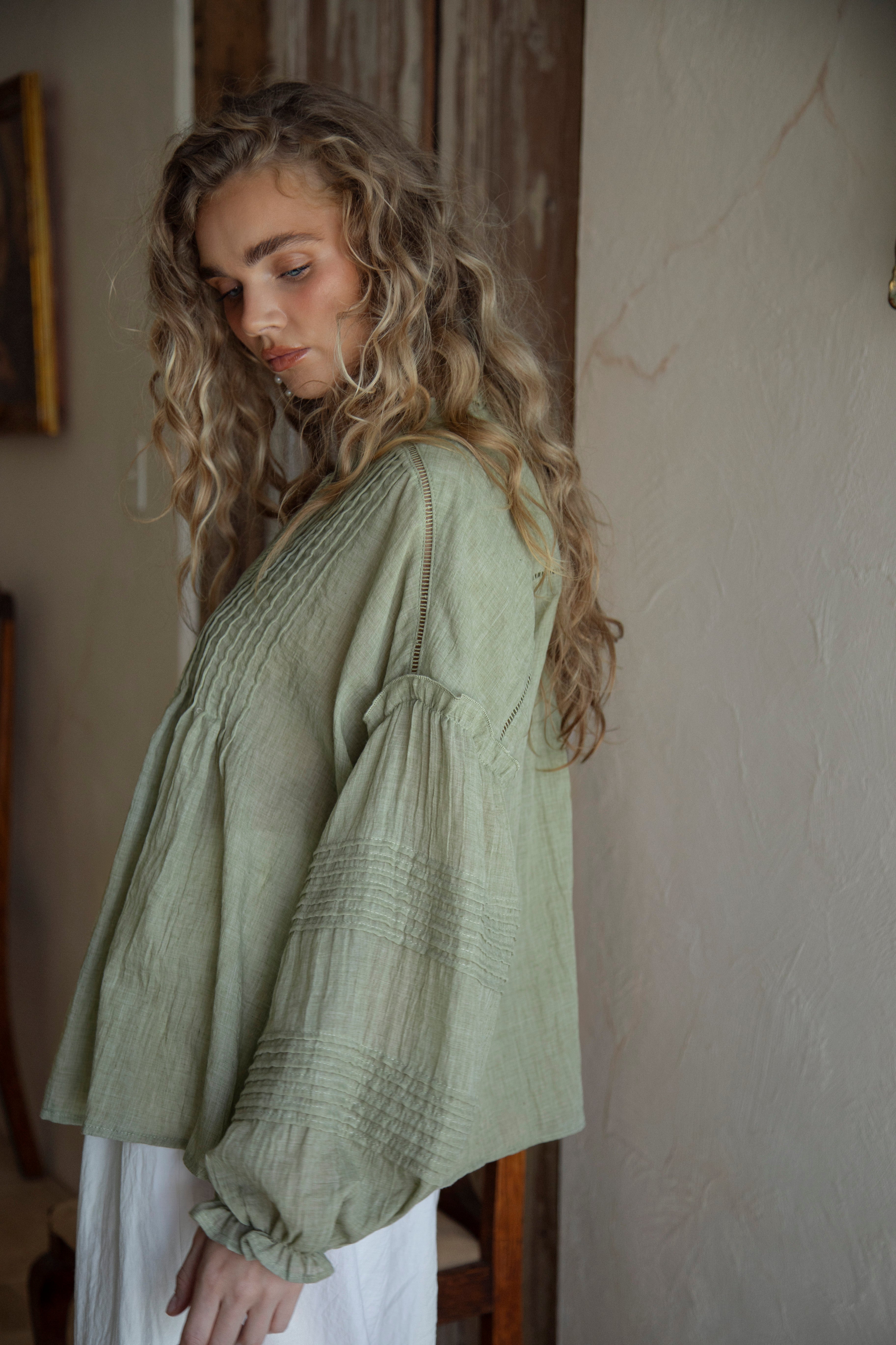 Poppy Blouse Fern - side view showcasing long sleeves with pintuck detail and ruffle at shoulder and hem.