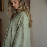 Poppy Blouse Fern - side view showcasing long sleeves with pintuck detail and ruffle at shoulder and hem.