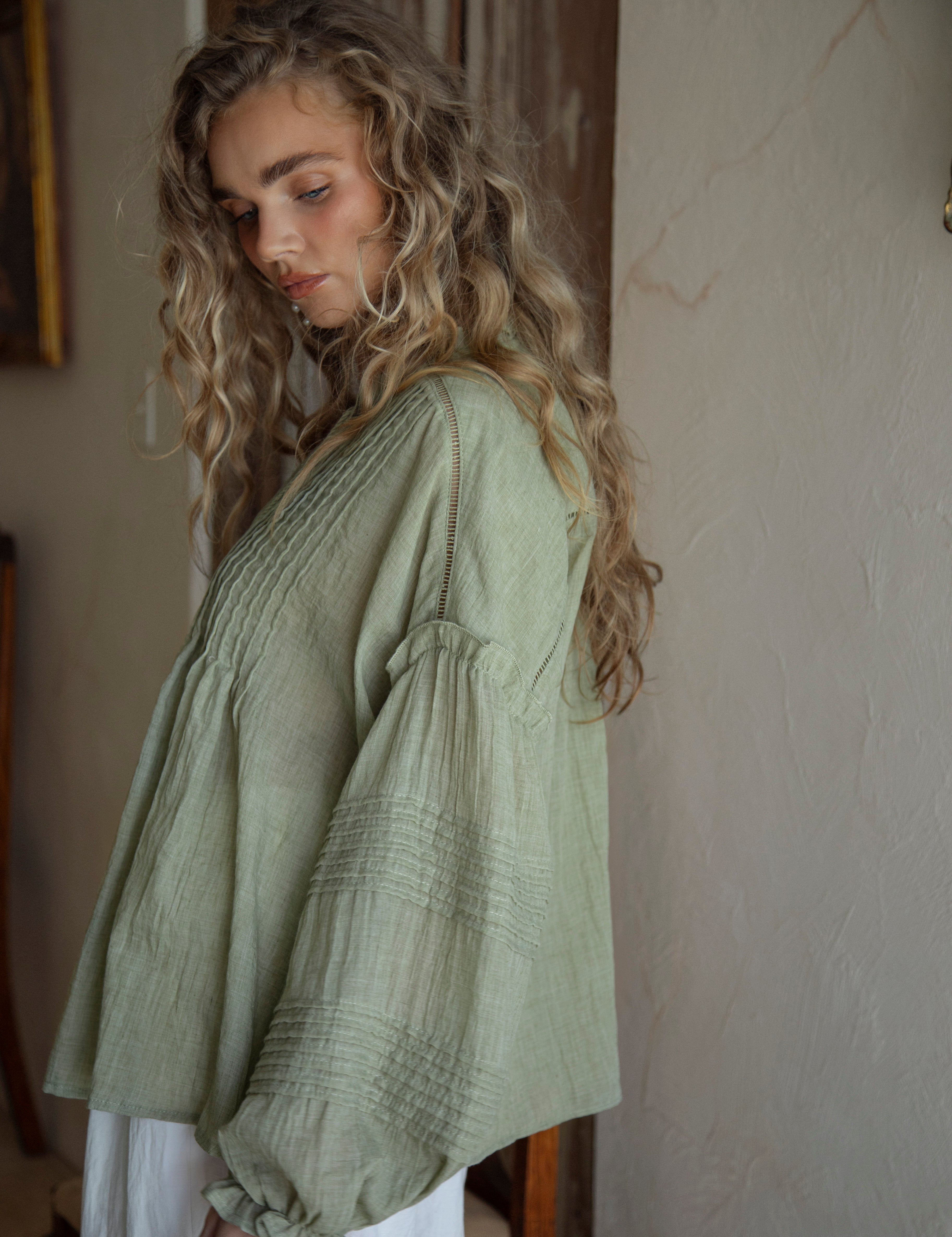 Poppy Blouse Fern - side view showcasing long sleeves with pintuck detail and ruffle at shoulder and hem.
