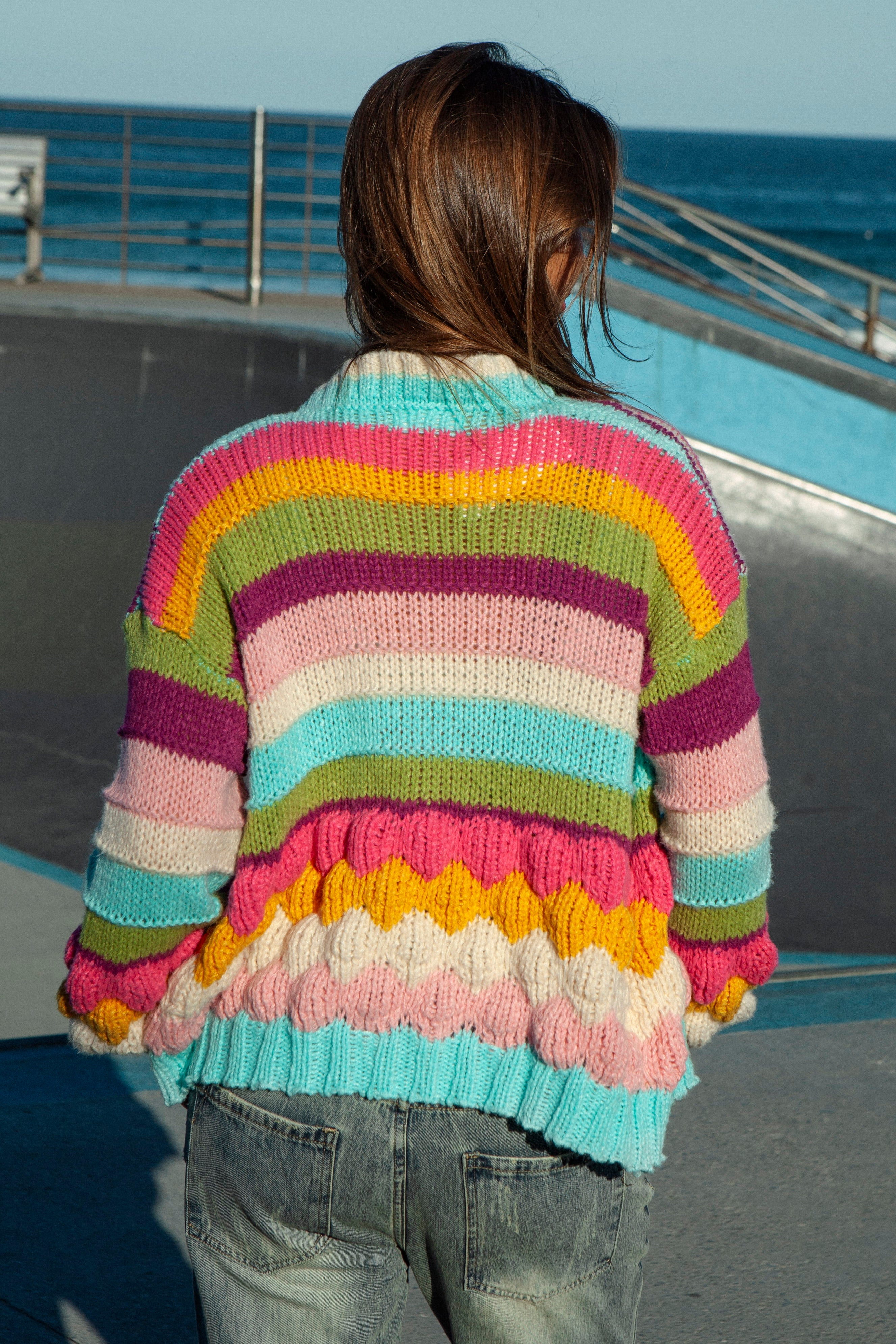Retro Rainbow Stripe Cardigan. Rear view showcasing textured knit and bright bold colours.