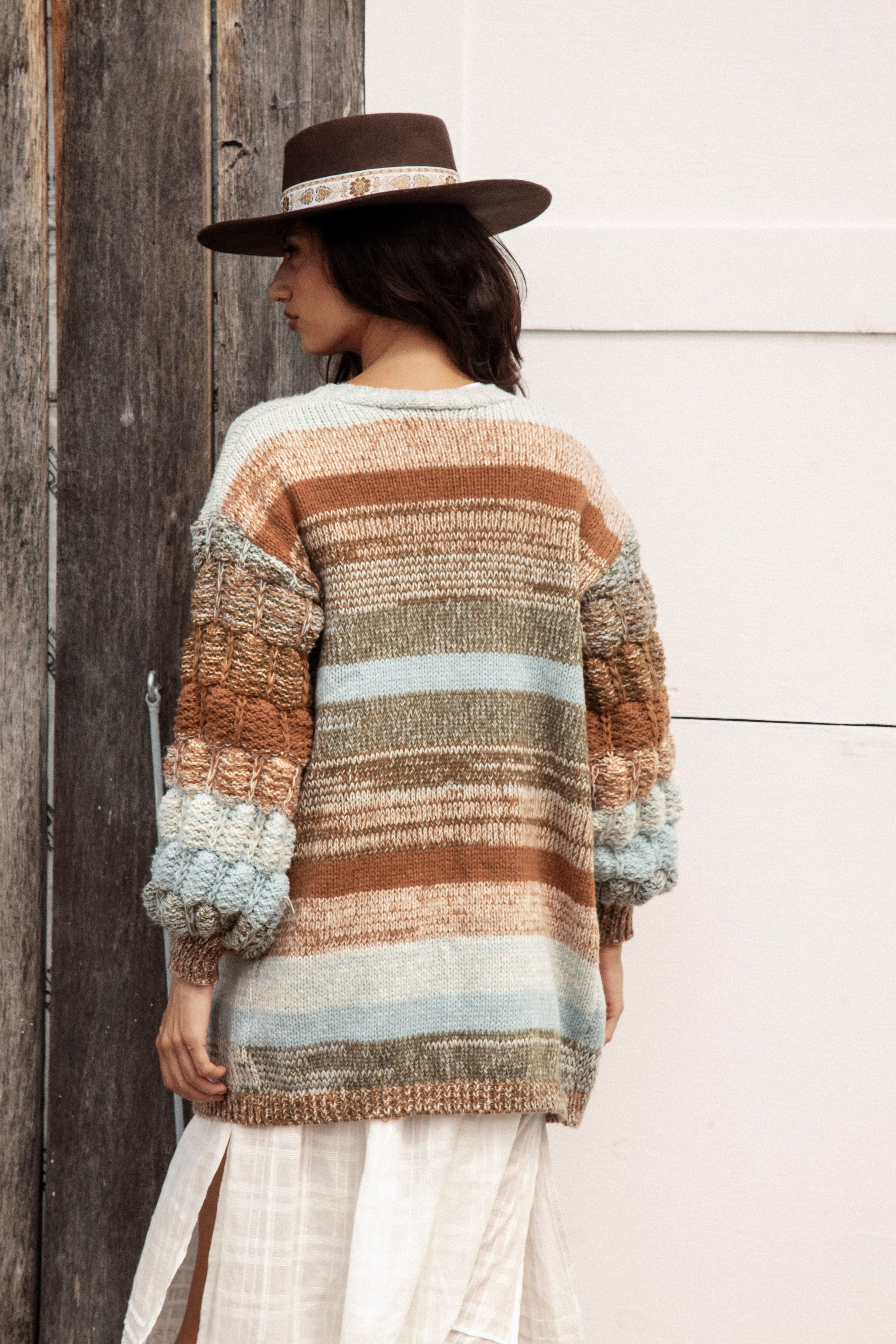Riverbend Stripe Cardi is a longline cardigan featuring chunky knit at sleeves and an ombré striped pattern.