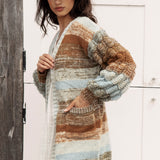 Riverbend Stripe Cardi featuring pockets and chunky knit at sleeves. ombré striped pattern in shades of pale blue, tan, brown and cream.