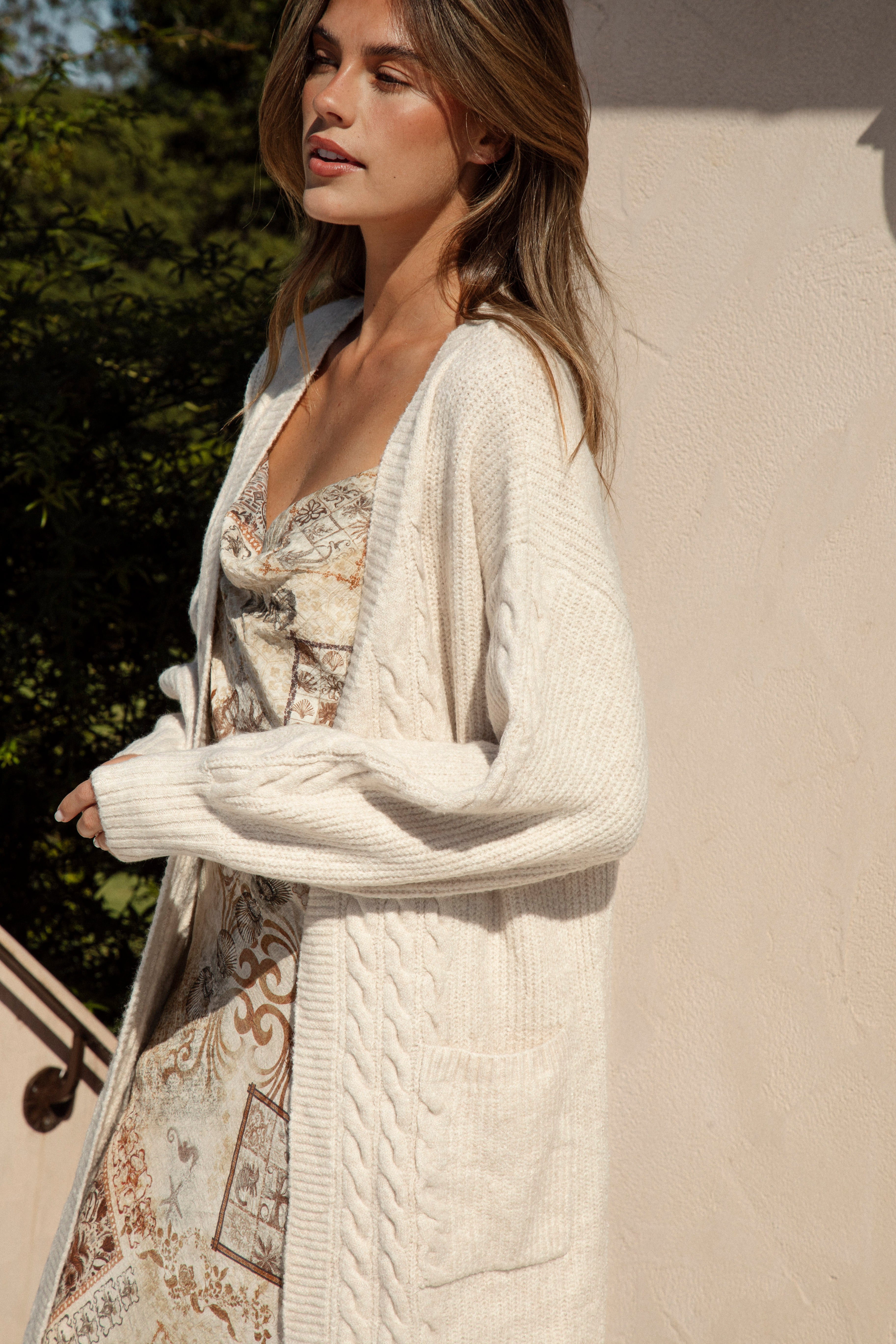 Romie Cable Cardigan Latte. Longline cardigan with statement pockets in neutral cream colourway.