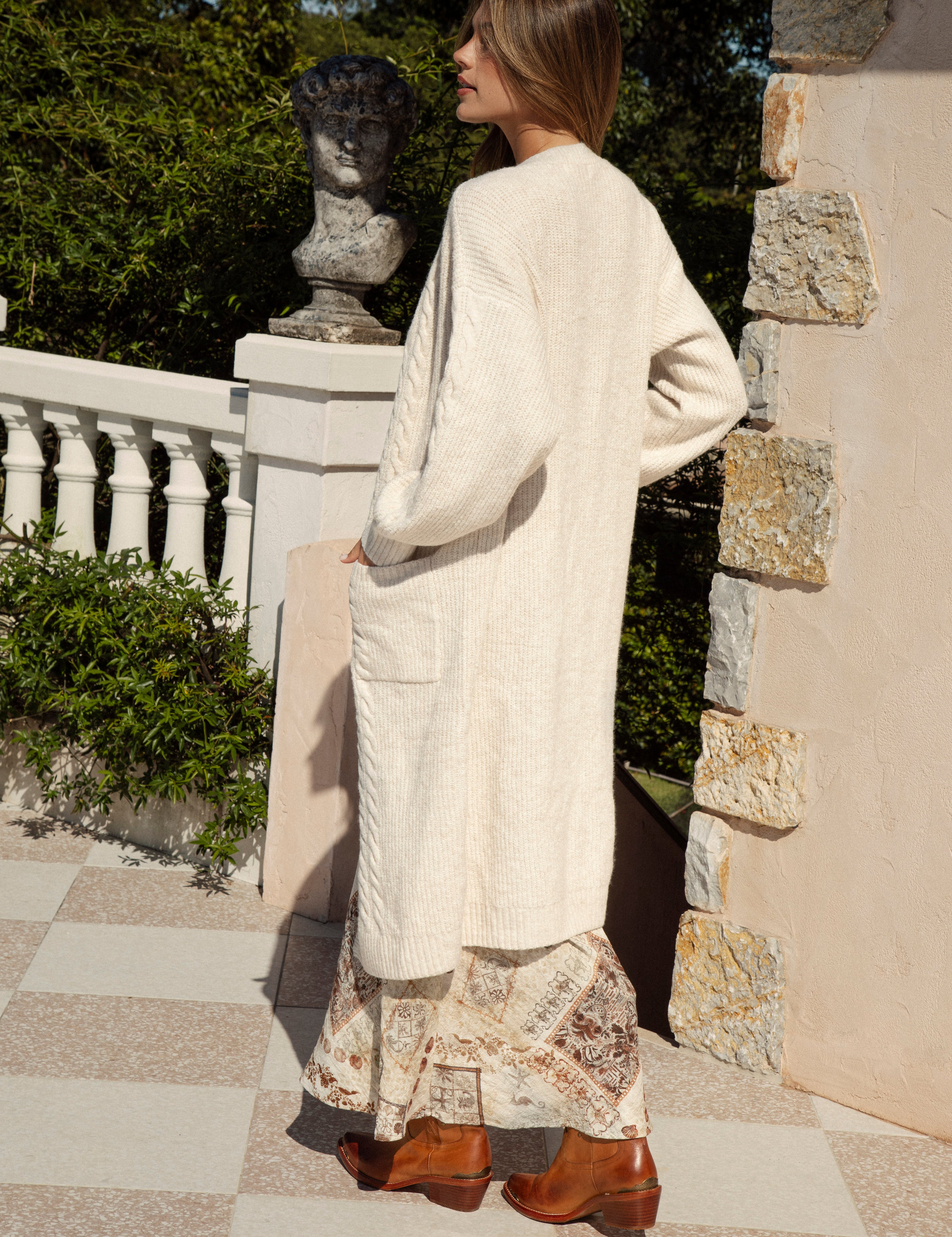 Romie Cable Cardigan Latte - rear view showcasing longline style, oversized fit and slight cable knit.