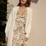 Romie Cable Cardigan Latte showcasing slight cable knit and neutral cream colourway. The perfect throw over piece.