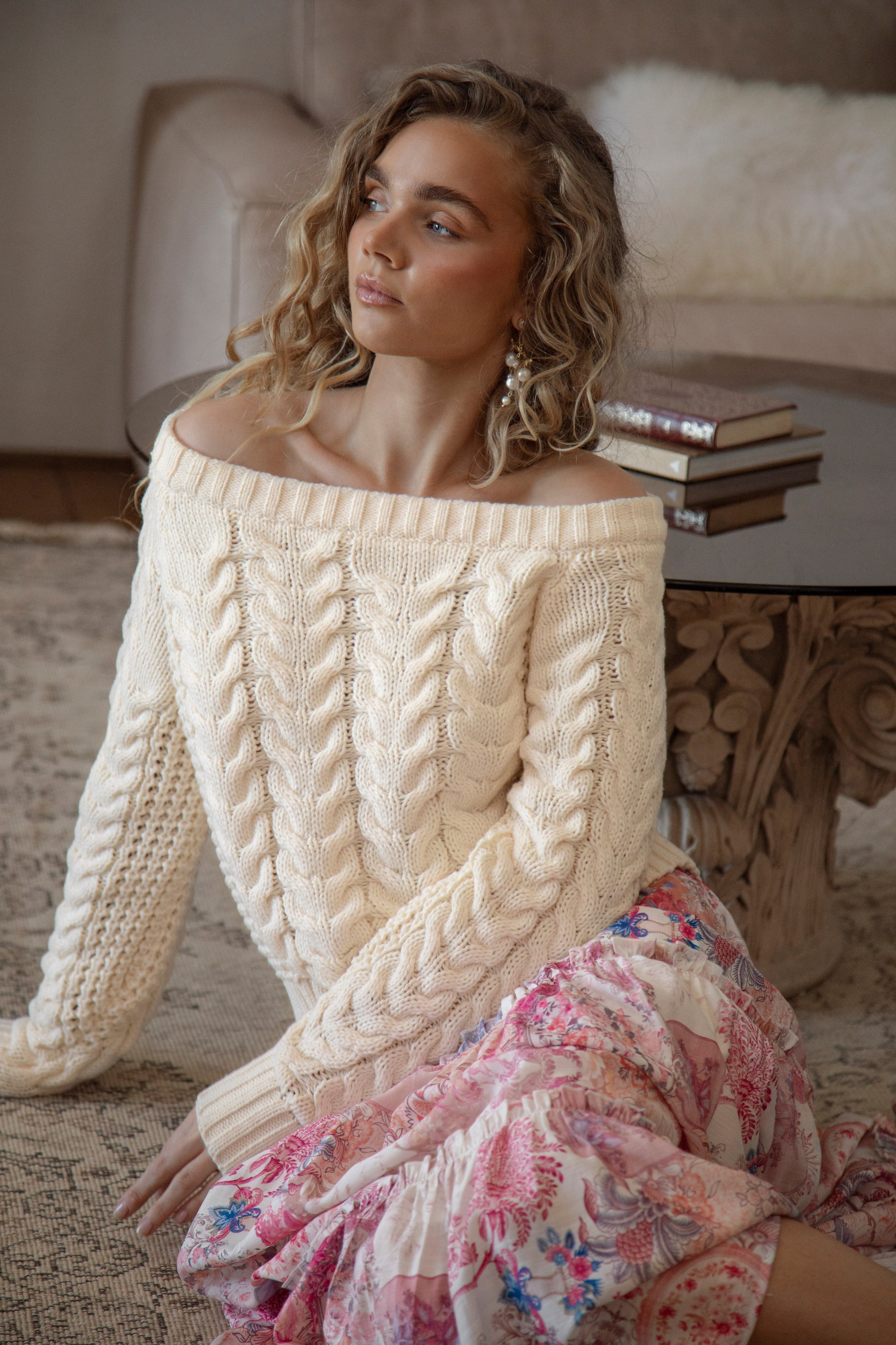 Seraphine Off Shoulder Knit Cream. A sweater in cream colourway featuring off the shoulder style and textured cable knit throughout.