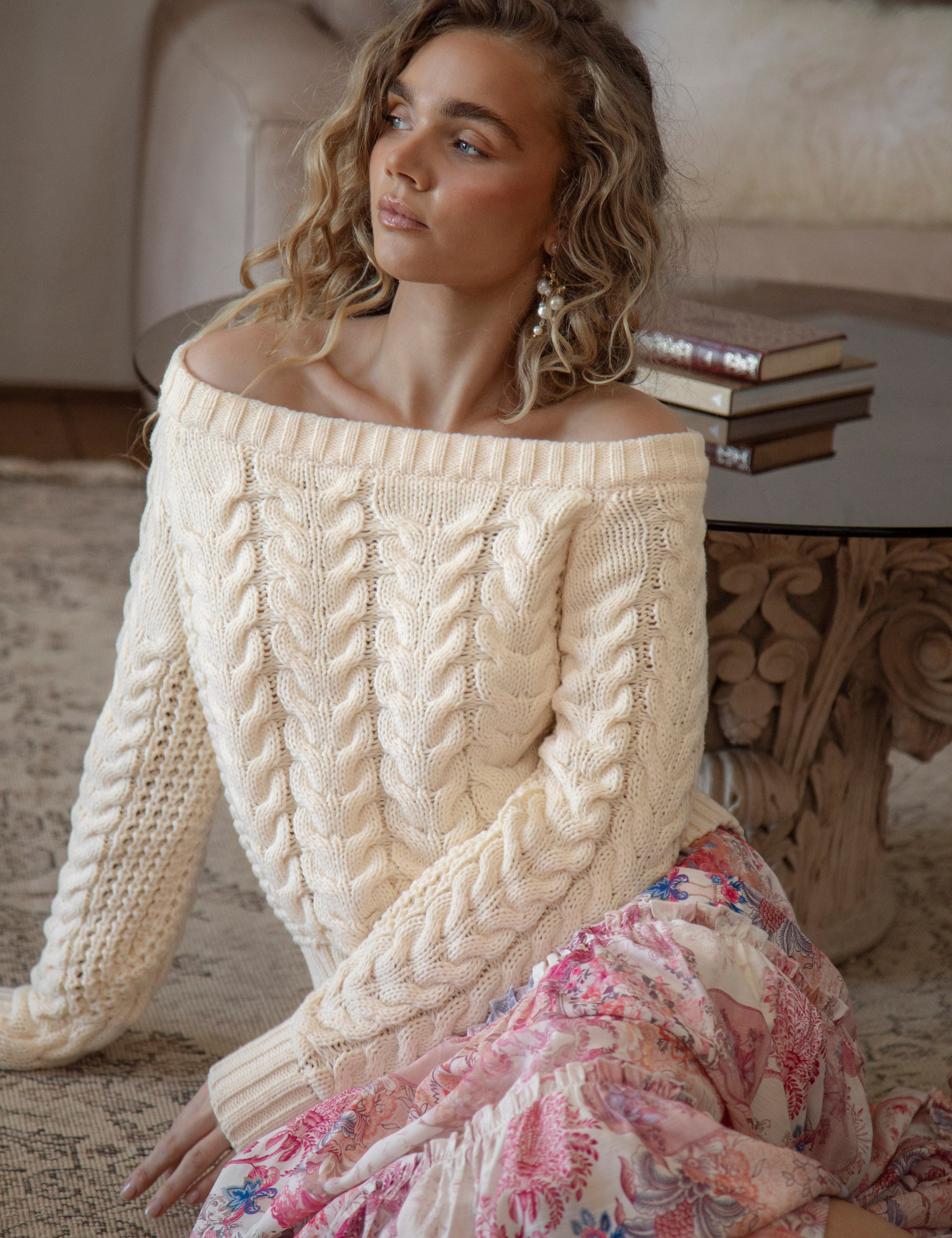 Seraphine Off Shoulder Knit Cream. A sweater in cream colourway featuring off the shoulder style and textured cable knit throughout.